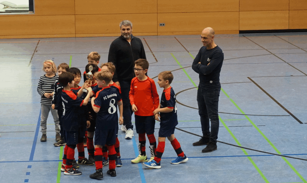 Mannschaft mit Pokal und Trainern beim ersten Turnier